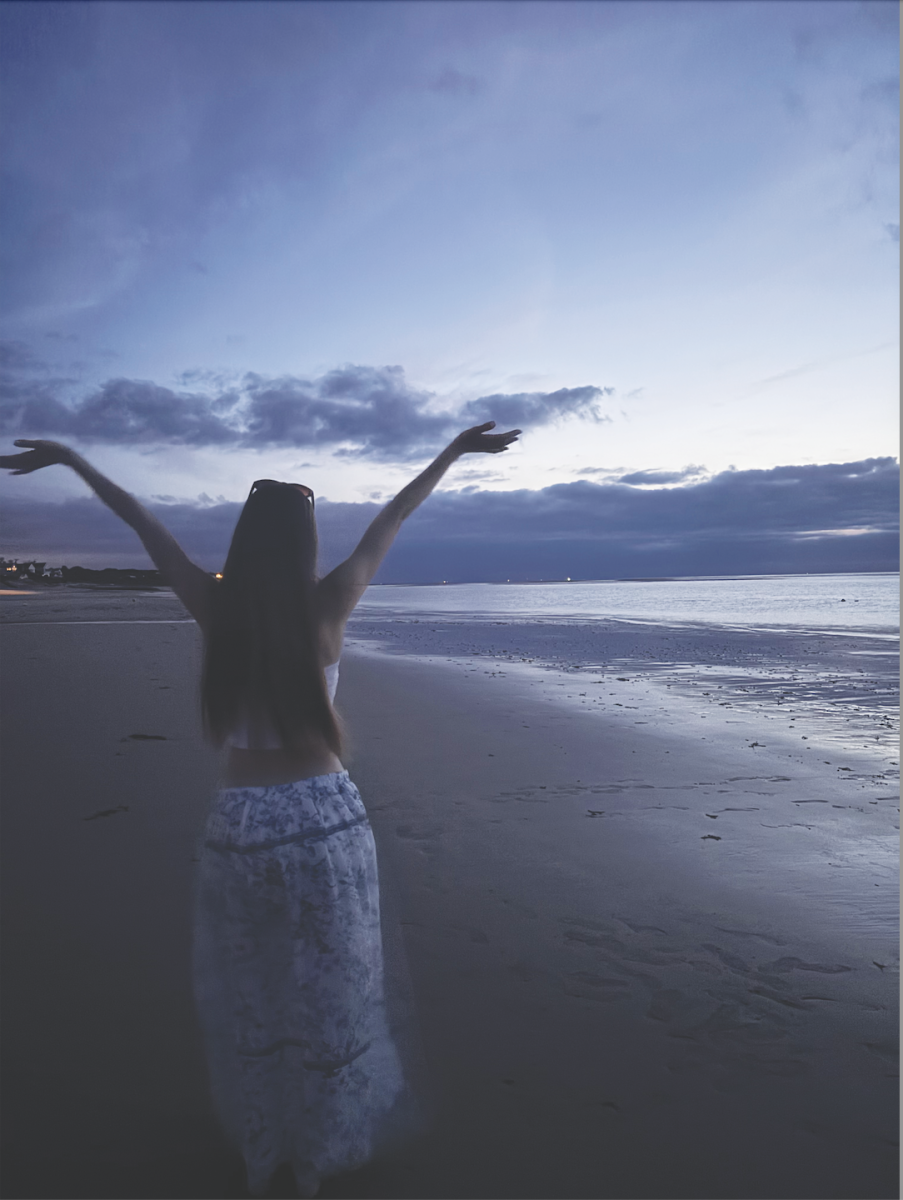 AN EVENING ON THE BEACH: Light from the houses and the setting sun illuminate the sand as I take in the view.